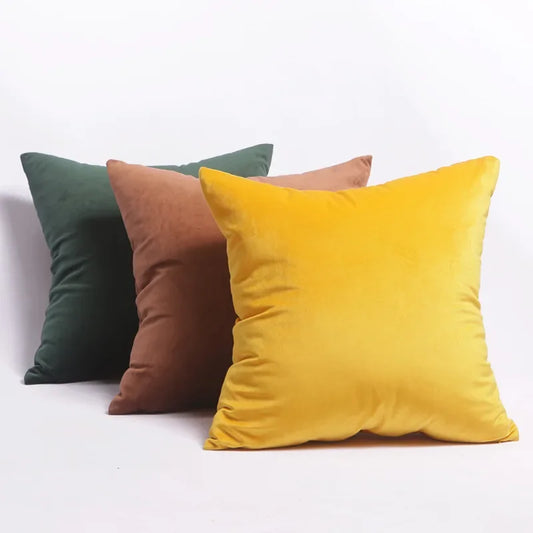 Cojines de terciopelo en tonos mostaza, verde y rosa