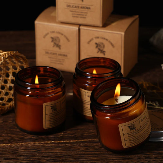 Velas perfumadas encendidas en tarros de cristal ámbar